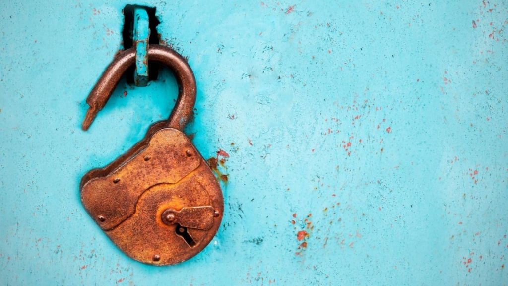 Rusted lock on blue wall